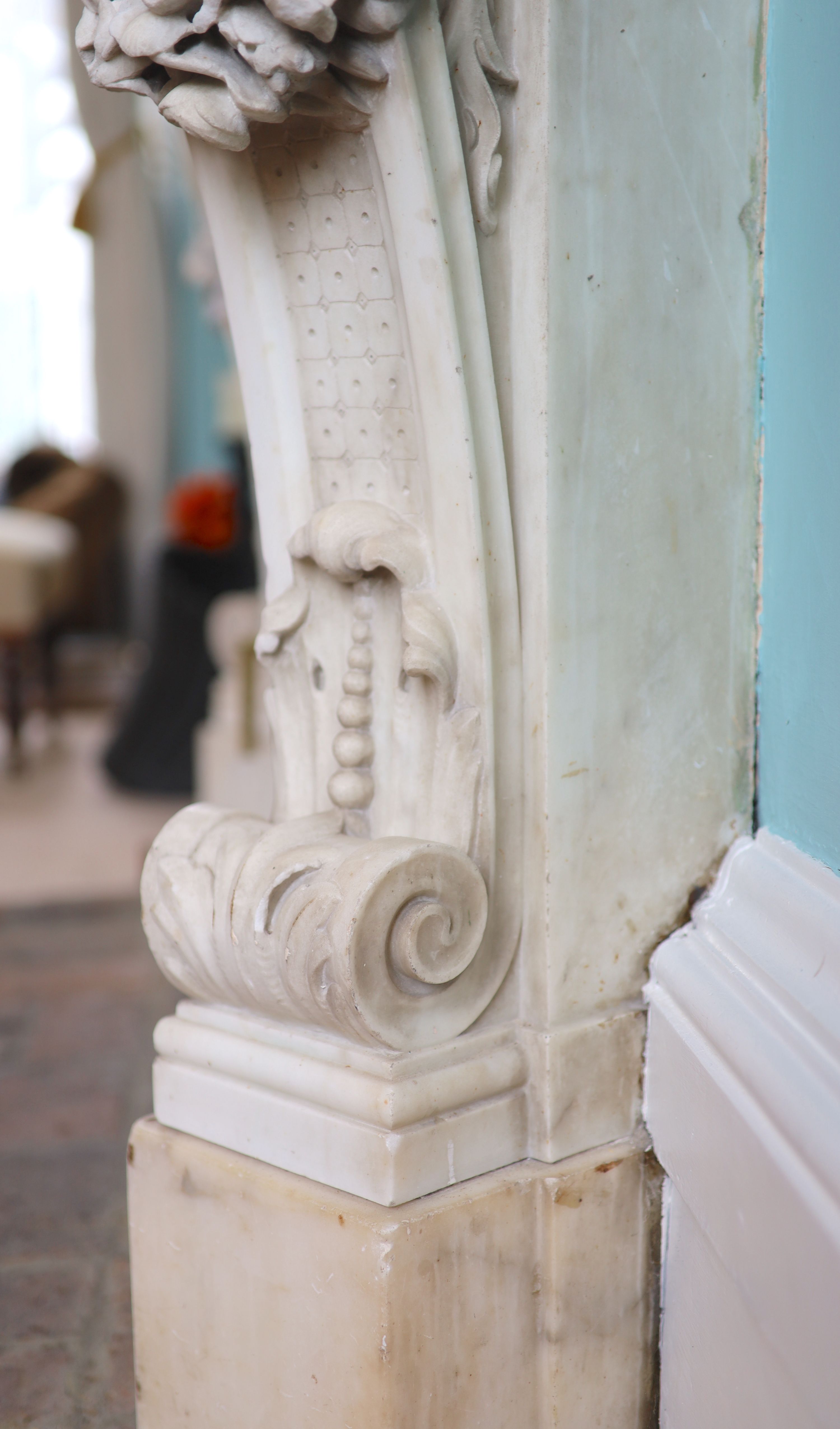 An important mid 19th century Italian white Carrara marble chimney piece, carved in the rococo taste, with seated putti, foliage swags